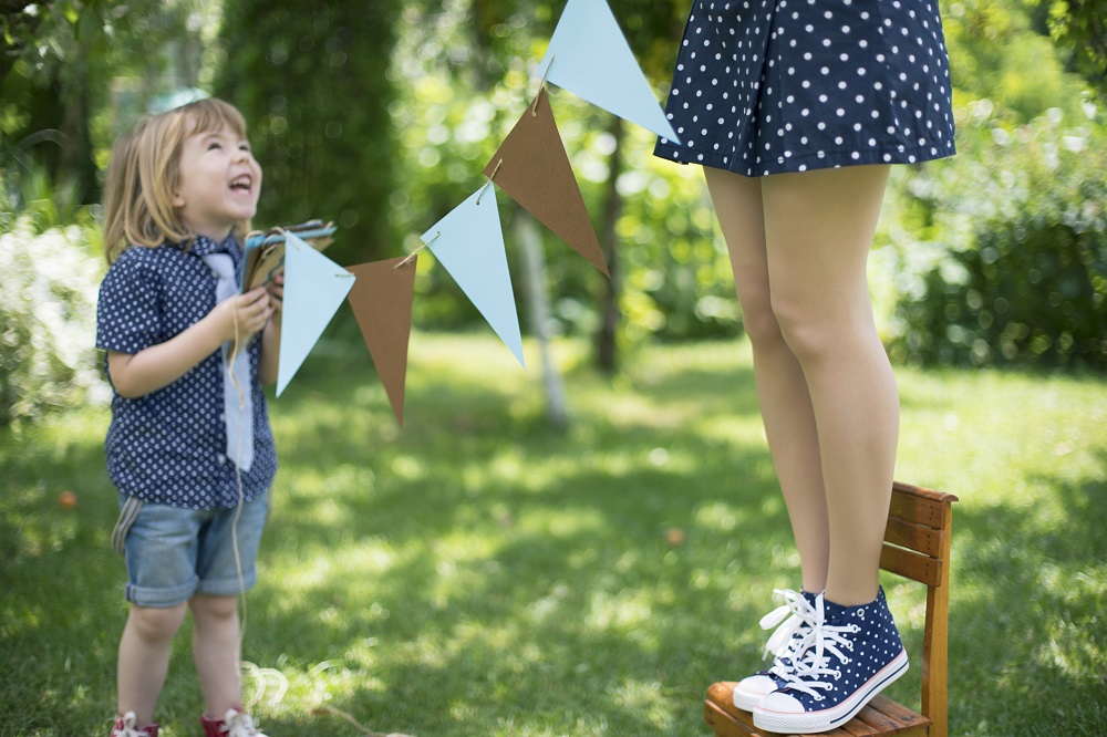 Kind und Mutter dekorieren für die Gartenparty