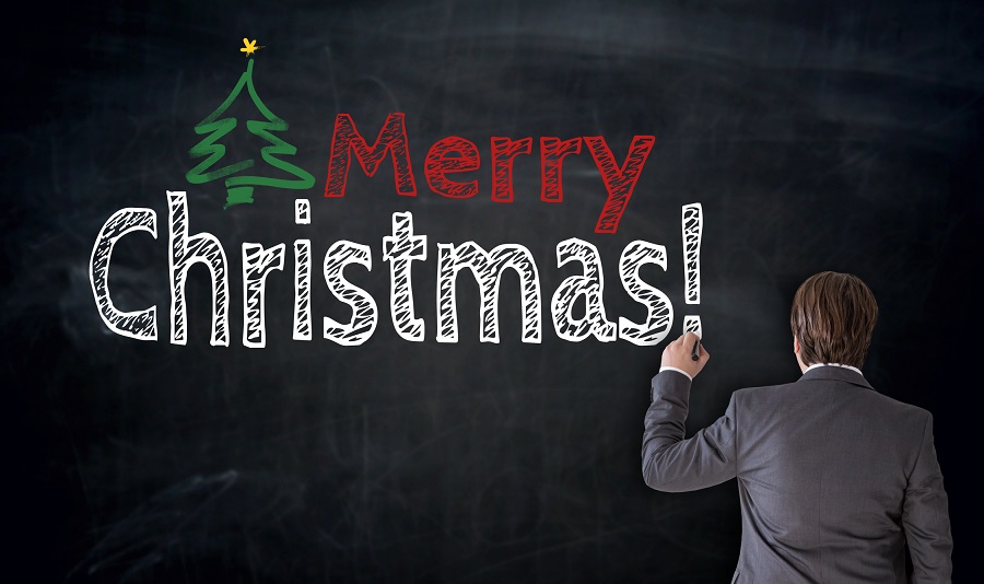 Geschäftsmann schreibt „Merry Christmas“ auf Tafel