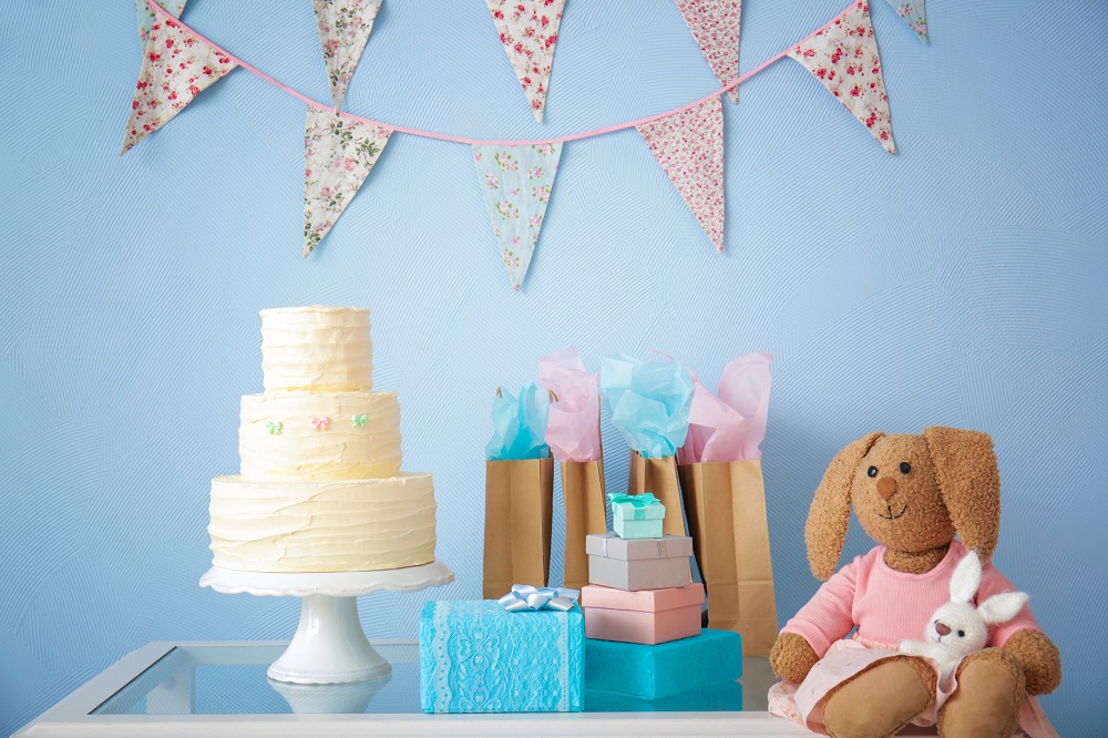Torte, Geschenke und Kuscheltiere für ein Baby