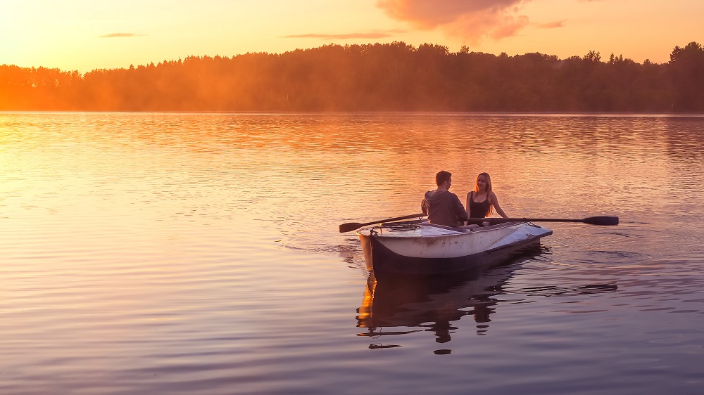 Paar auf dem Boot bei Sonnenuntergang