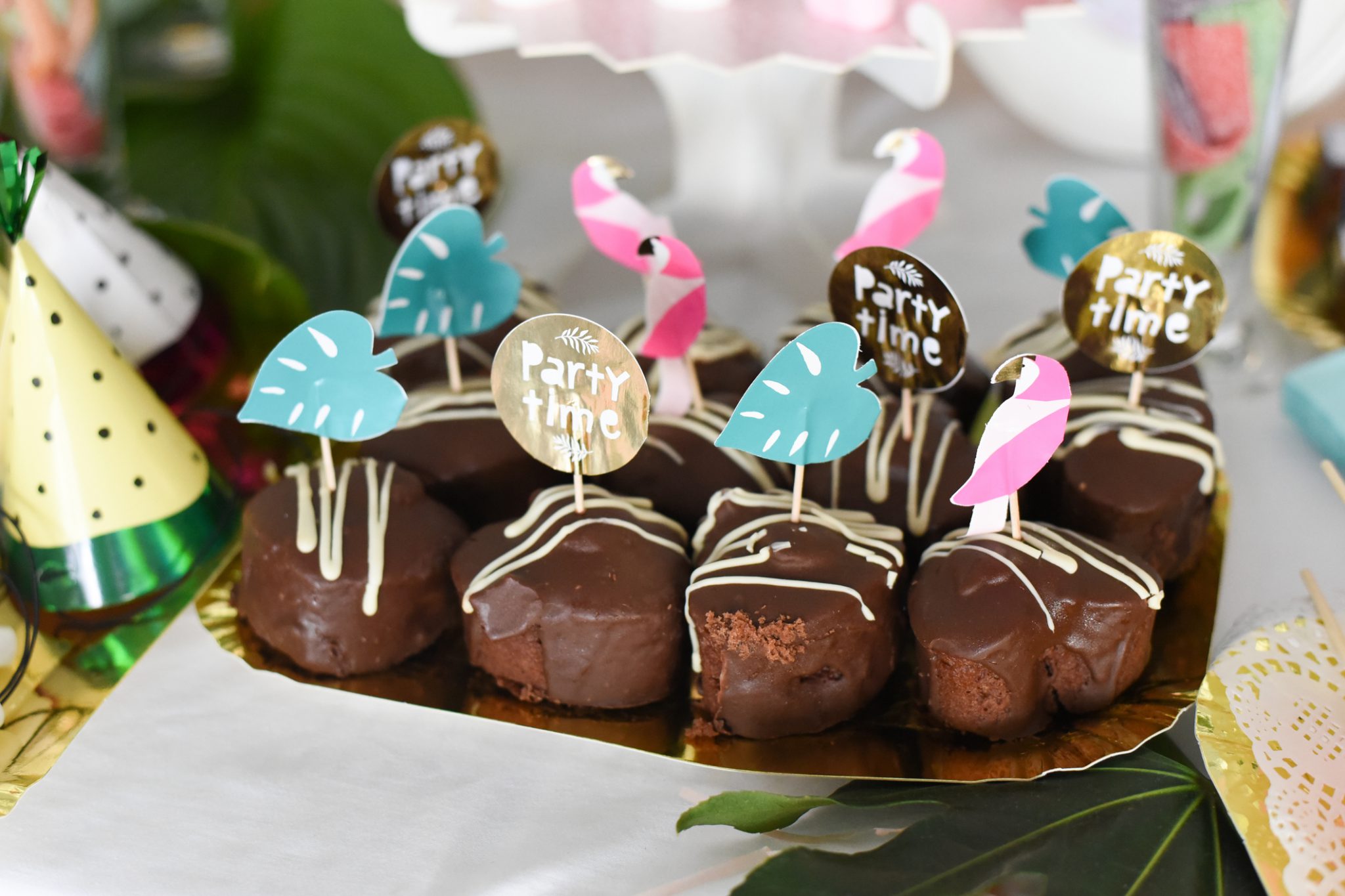 Buffet mit kleinen Kuchen und tropischer Deko 