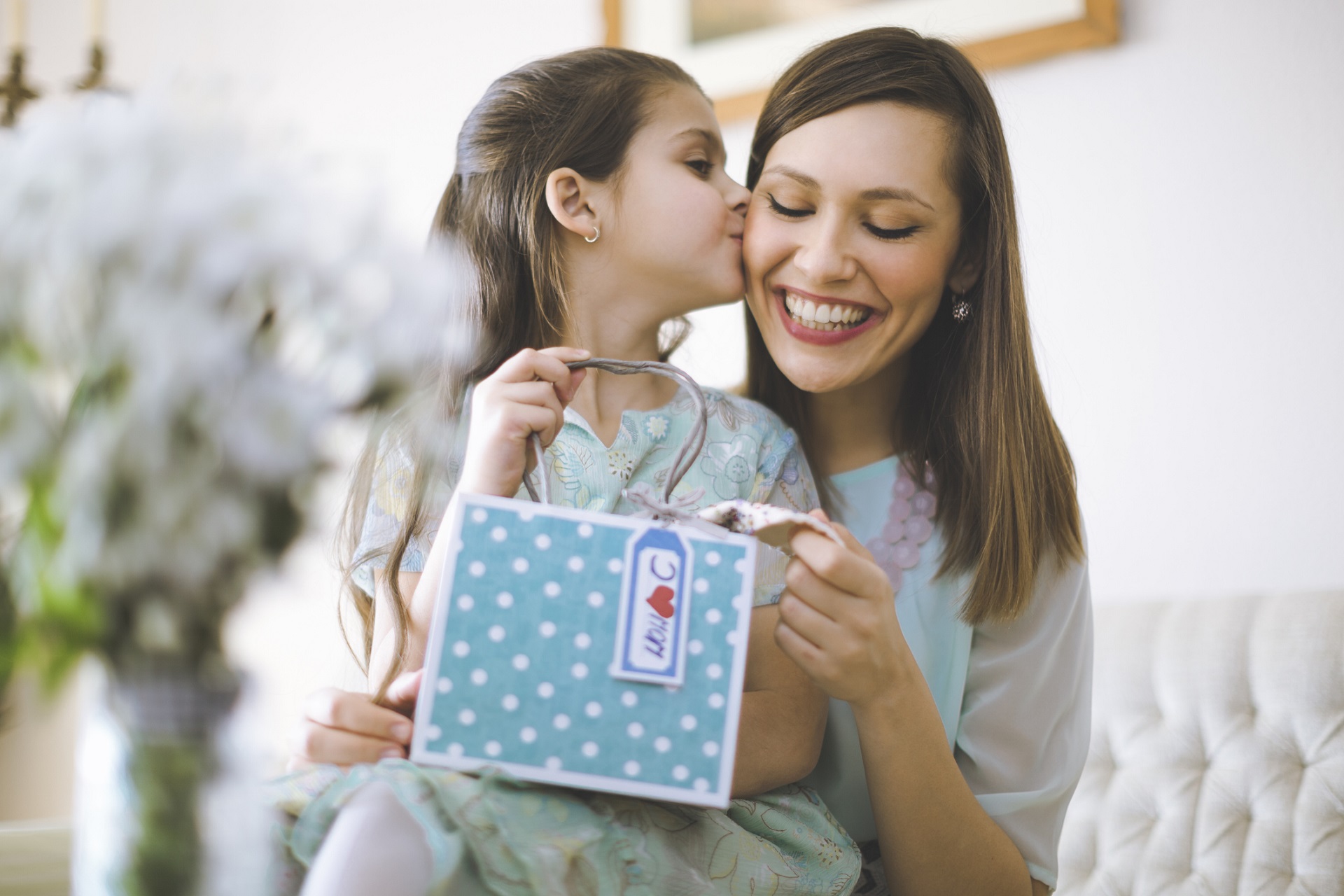 Alt-Tag: Kind übergibt ihrer Mama ein Geschenk zum Muttertag.