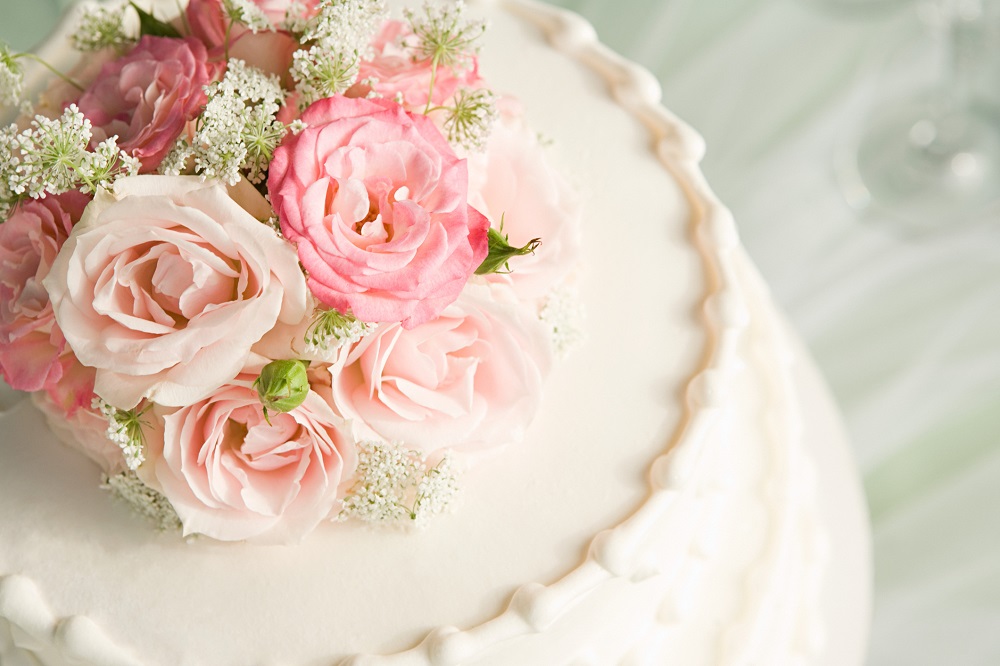 weiße Fondant-Hochzeitstorte mit rosa Blumentopping