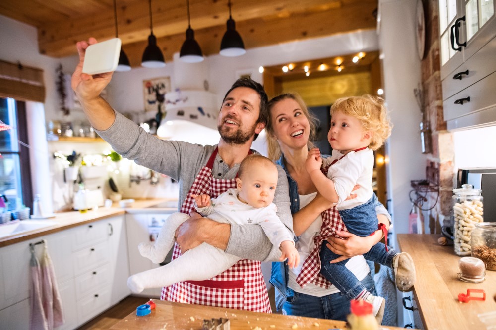Familie mit zwei Kindern macht Selfie in der Küche