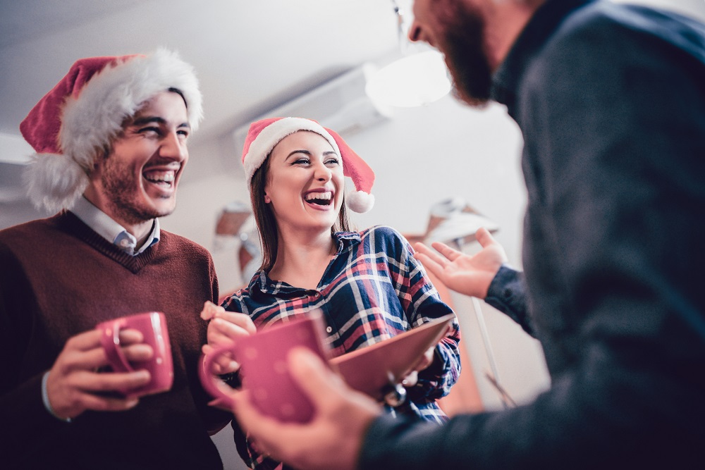 Kollegen lachen bei Smalltalk auf der betrieblichen Weihnachtsfeier