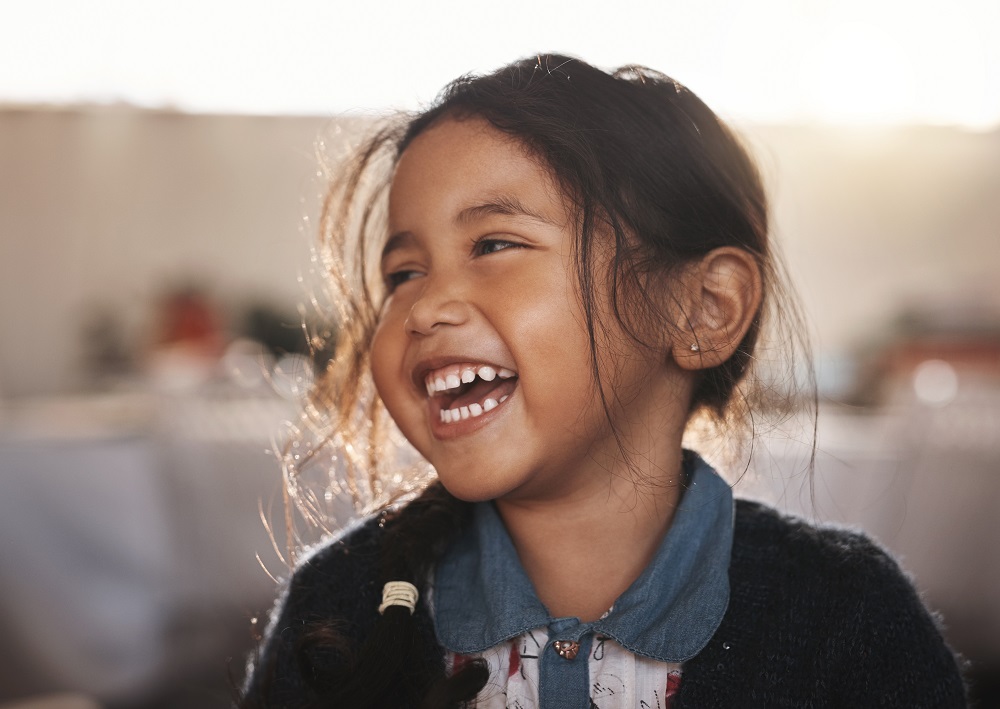 Mädchen lacht beim Spielen am Kindergeburtstag