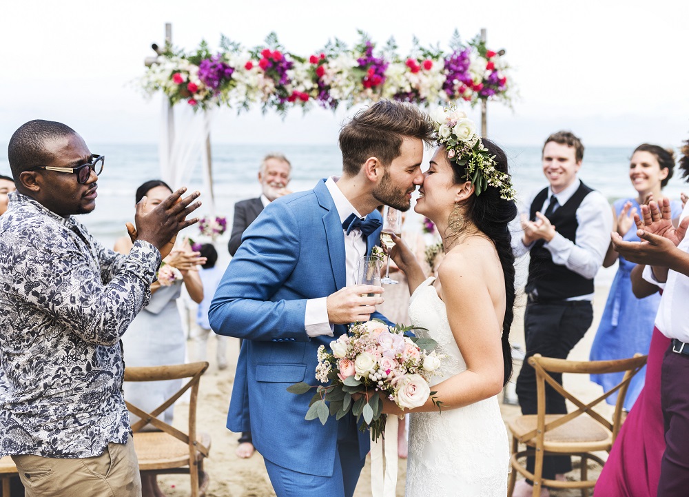 Sich küssendes Hochzeitspaar als Symbolbild für Hochzeitseinladungen, die das Motto der Hochzeit aufgreifen