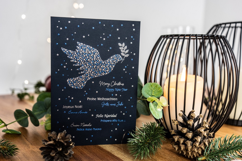 Weihnachtskarte mit Taube vor Dekoration