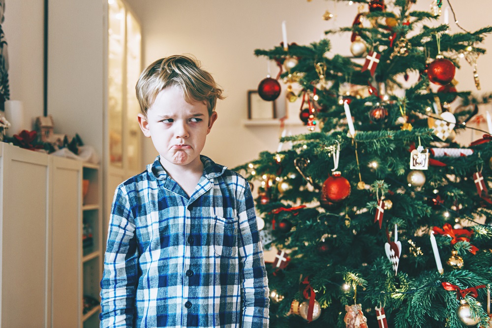 Kind schaut grimmig fürs Weihnachtsfoto