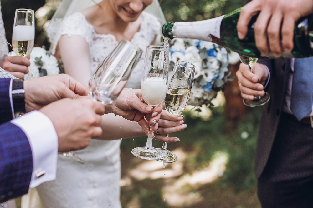 Brautpaar und Gäste mit Sektgläsern bei Hochzeit