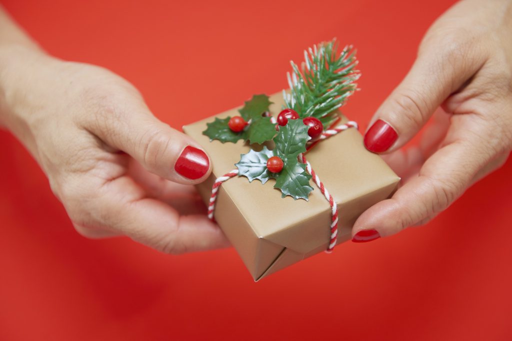 Frau überreicht geschäftliches Weihnachtsgeschenk