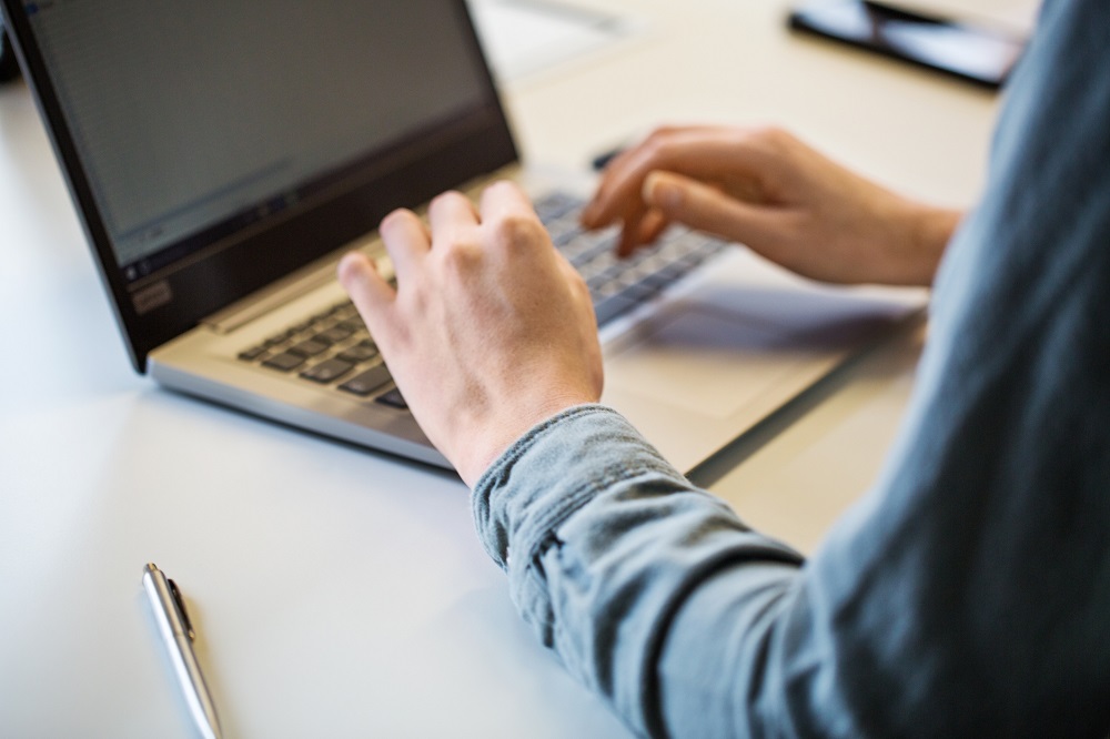 Person am Laptop sucht nach der richtigen Grußformel