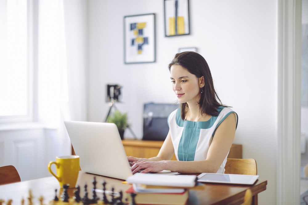 Frau im Home Office schreibt geschäftlichen Brief