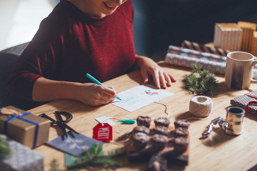 Frau unterschreibt eine Weihnachtskarte