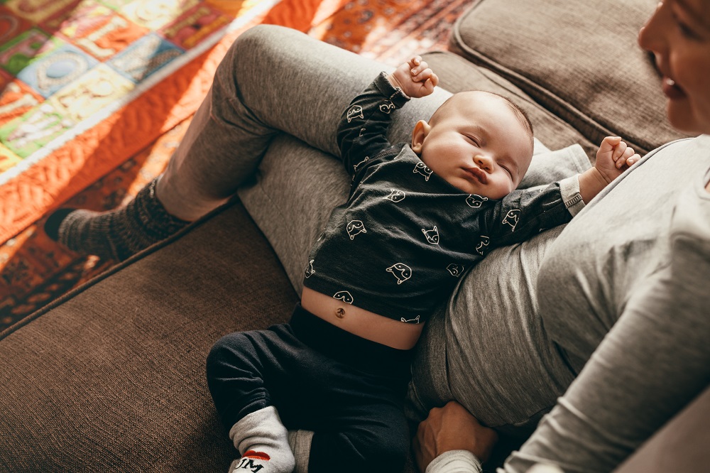 Baby schläft bei Mama auf dem Sofa