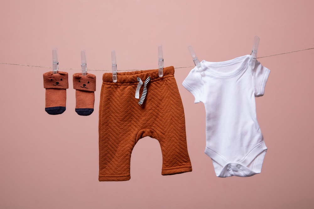 Babykleidung hängt nebeneinander an einer Wäscheleine