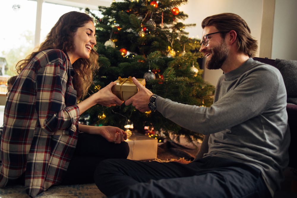 Mann überreicht Weihnachtsgeschenk seiner Frau