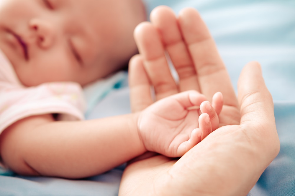 Frau hält Hand von Baby