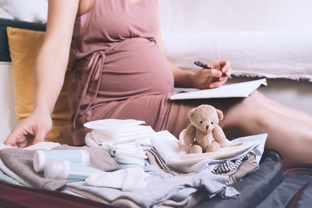 Frau macht Checkliste während Schwangerschaft