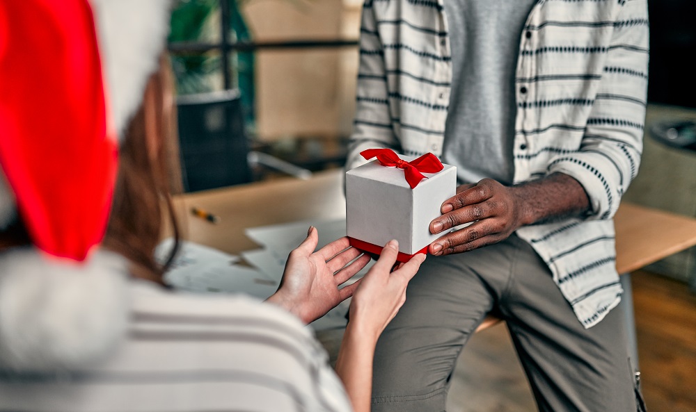 Frau übergibt Kollegen ein Weihnachtsgeschenk