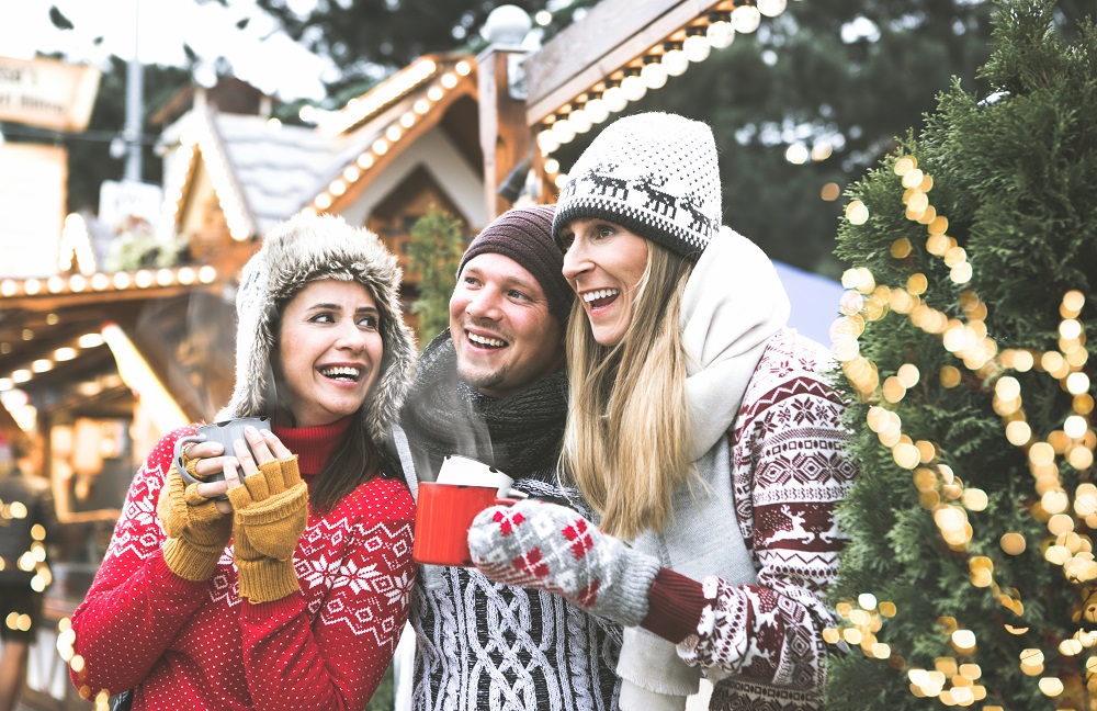 Kollegen trinken Glühwein auf Weihnachtsmarkt