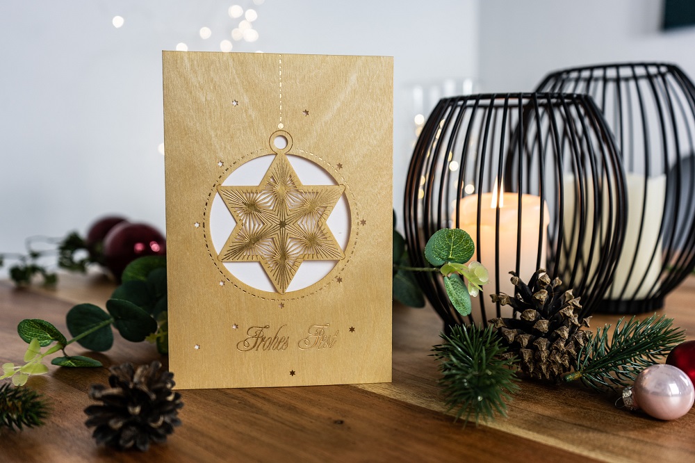 Weihnachtskarte aus Holz vor Dekoration