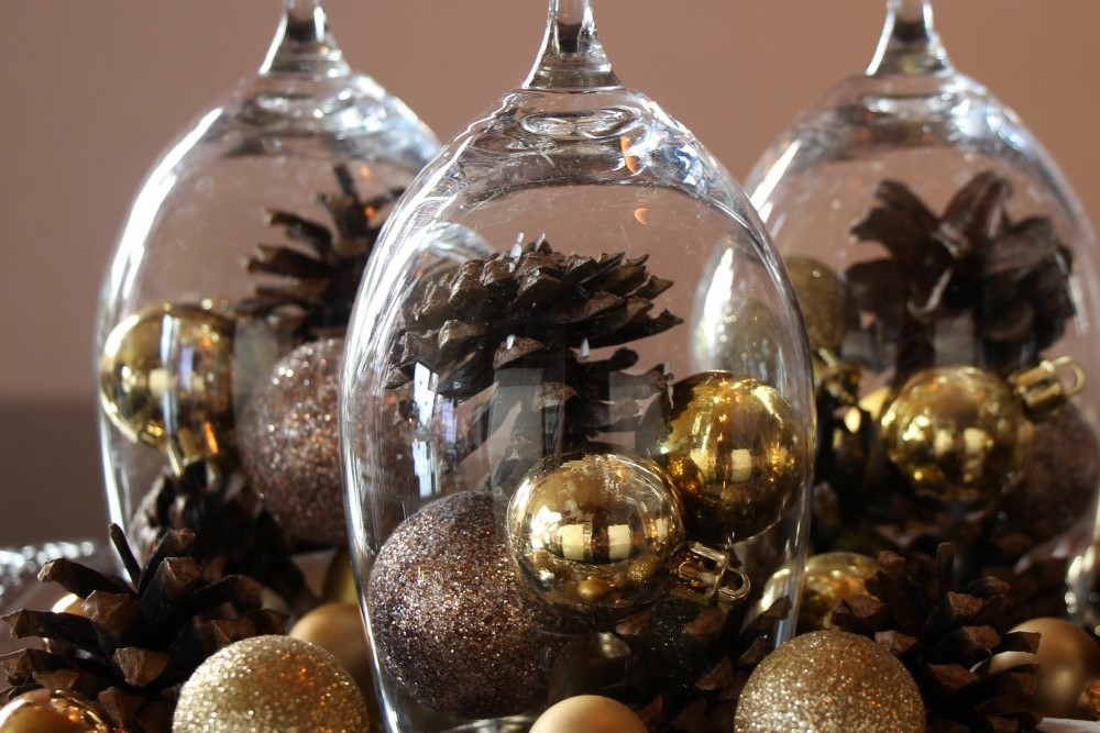goldene Christbaumkugeln unter Weingläsern dekoriert