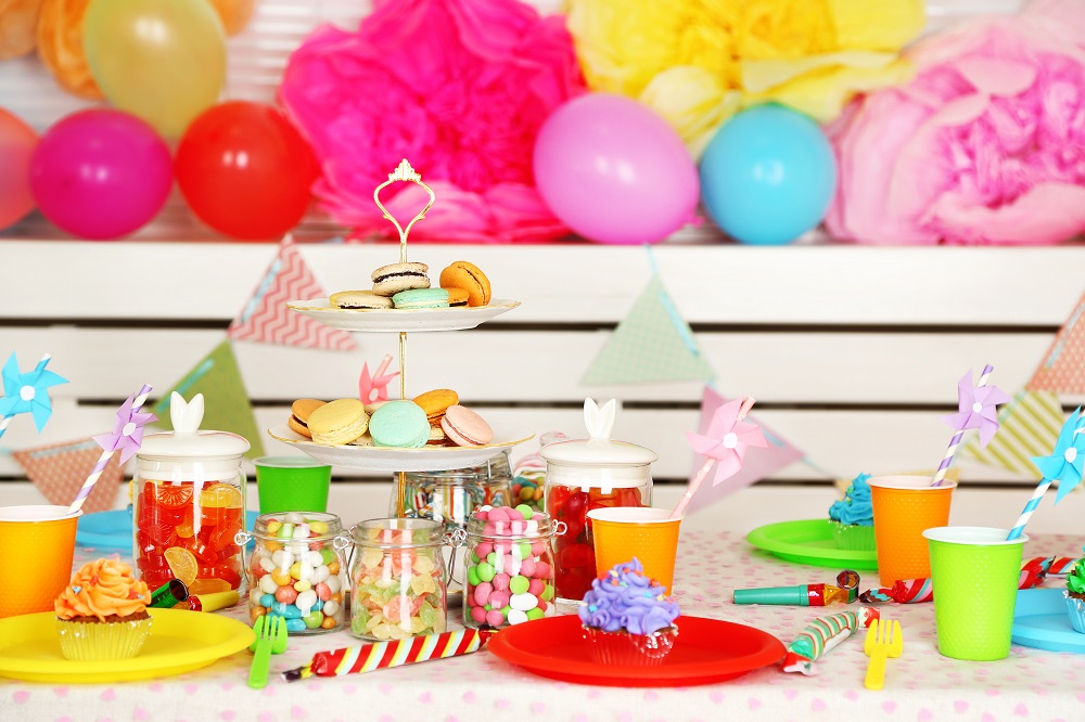 Bunte Luftballons und Süßigkeiten als Deko auf dem Kindertisch 