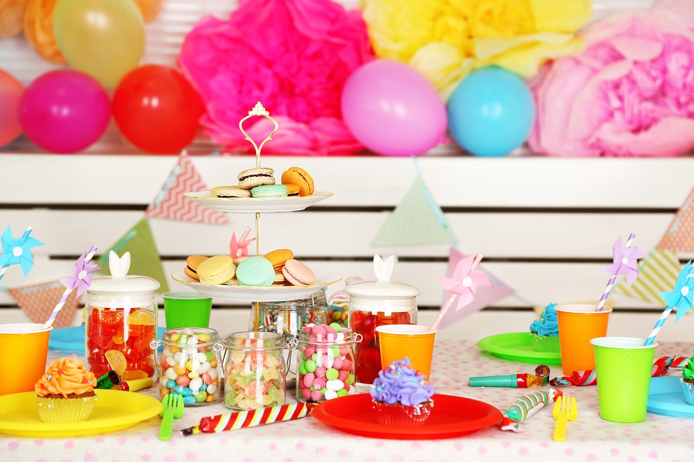 Bunte Luftballons und Süßigkeiten als Deko auf dem Kindertisch